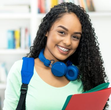 Mujer joven sonriente con aparatos dentales en Pearly Whites de Pearland.