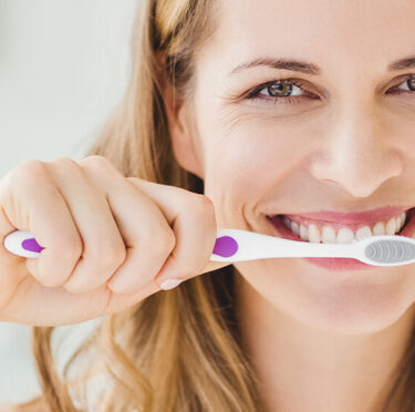 A lady brushing her teeth