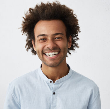 A man smiling after getting teeth whitening treatment
