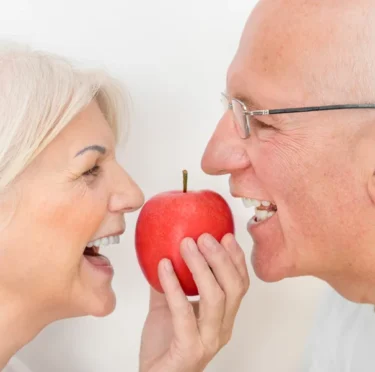 An old couple smiling after getting dentures