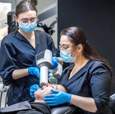La Dra. Paola Argaez, dentista de habla hispana en Pearland, atendiendo a un paciente en Pearly Whites of Pearland.