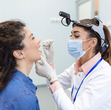 La Dra. Paola Argaez, dentista de habla hispana en Pearland, examina a un paciente.