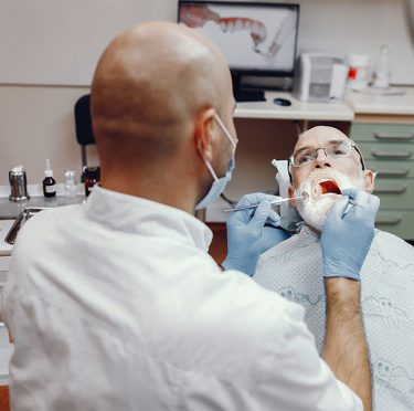 La Dra. Paola Argaez, dentista bilingüe en Pearland, atendiendo a un paciente en un consultorio dental moderno.