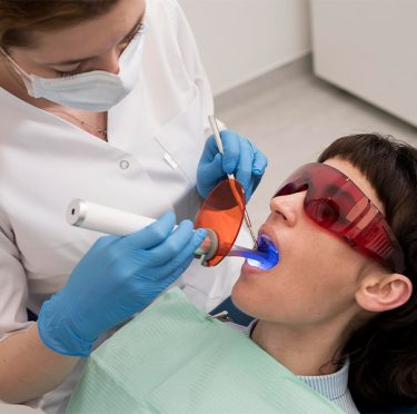 Dentista realizando procedimiento en Pearly Whites of Pearland, servicio bilingüe disponible.