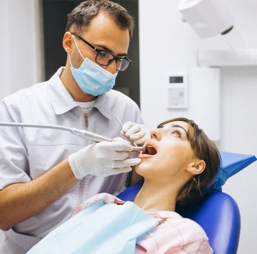 Dentista en Pearland examinando los dientes de un paciente, Pearly Whites of Pearland.