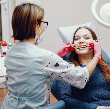 Dentista de habla hispana examinando a un paciente en Pearly Whites of Pearland.