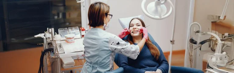 Dentista de habla hispana examinando a un paciente en Pearly Whites of Pearland.