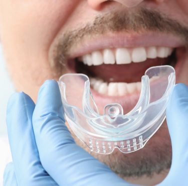 Paciente en Pearly Whites of Pearland recibiendo atención dental con protector bucal.