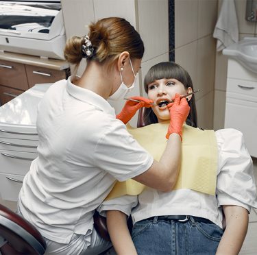 La Dra. Paola Argaez, dentista de habla hispana en Pearland, examina a un paciente.