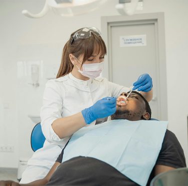 La Dra. Paola Argaez, dentista de habla hispana en Pearland, atendiendo a un paciente en Pearly Whites of Pearland.