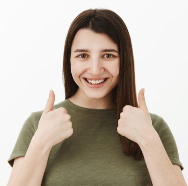 Mujer sonriente dando pulgares hacia arriba en Pearly Whites of Pearland, dentista en Pearland TX.