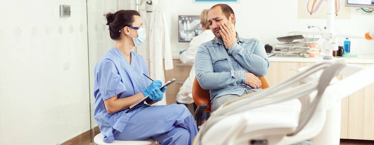 Dentista consultando con paciente en el consultorio dental Pearly Whites de Pearland.